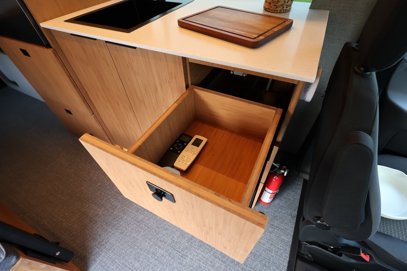Open kitchen drawer in the Aire galley with fan and light remotes stored inside